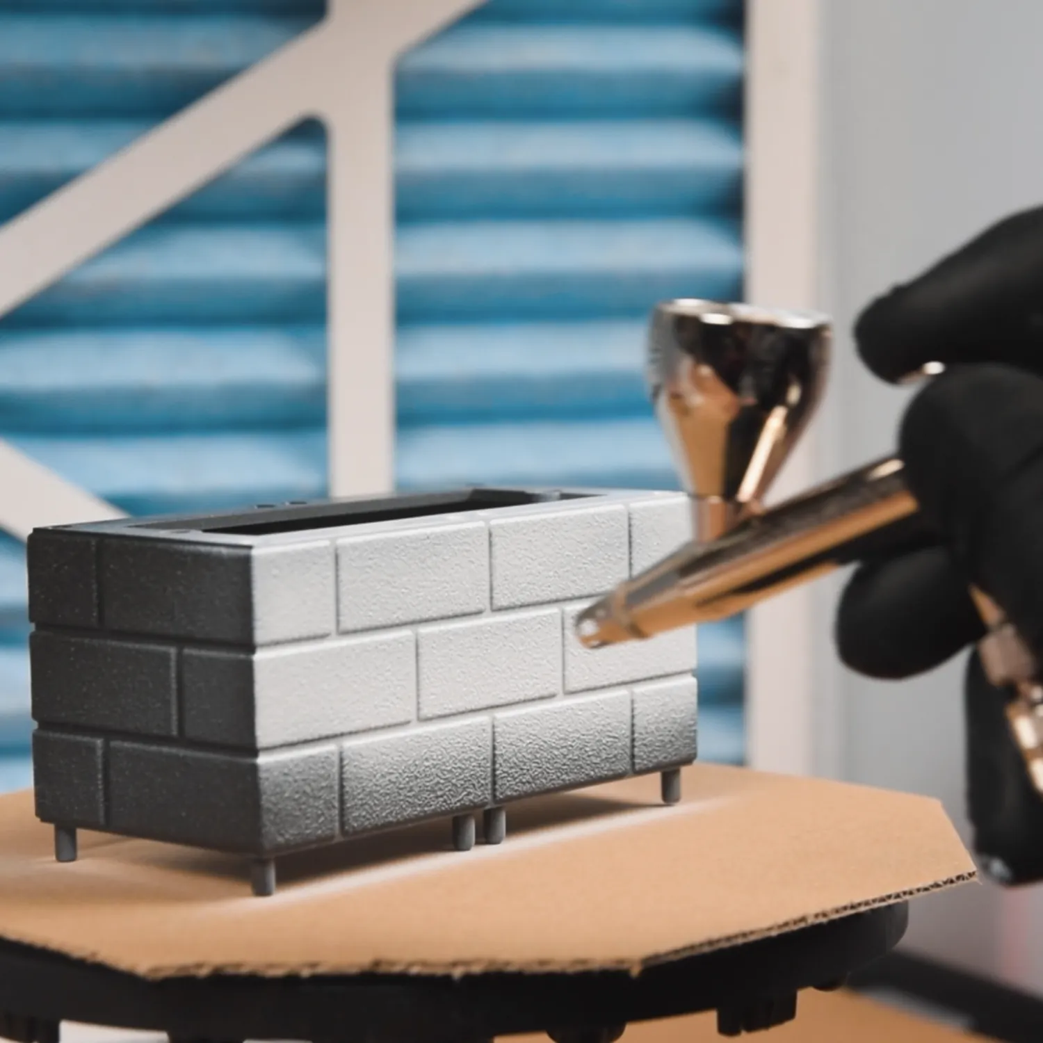 Graues Modellteil wird weiß mit der Airbrush grundiert.